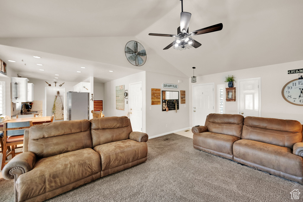 Carpeted living area featuring vaulted ceiling, recessed lighting, and a ceiling fan