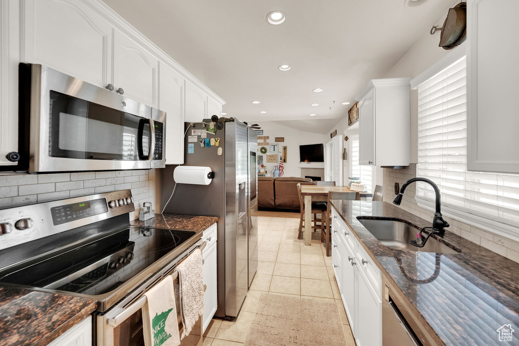 Kitchen featuring stainless steel appliances, white cabinets, tasteful backsplash, recessed lighting, and light tile patterned flooring
