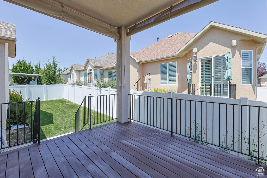 Wooden terrace with a fenced backyard and a residential view