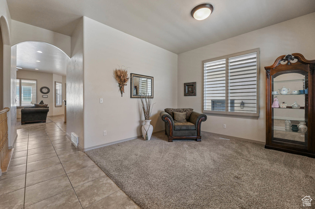 Living area featuring arched walkways, light tile patterned floors, and recessed lighting
