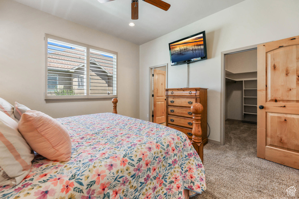 Carpeted bedroom with a spacious closet, a ceiling fan, and recessed lighting