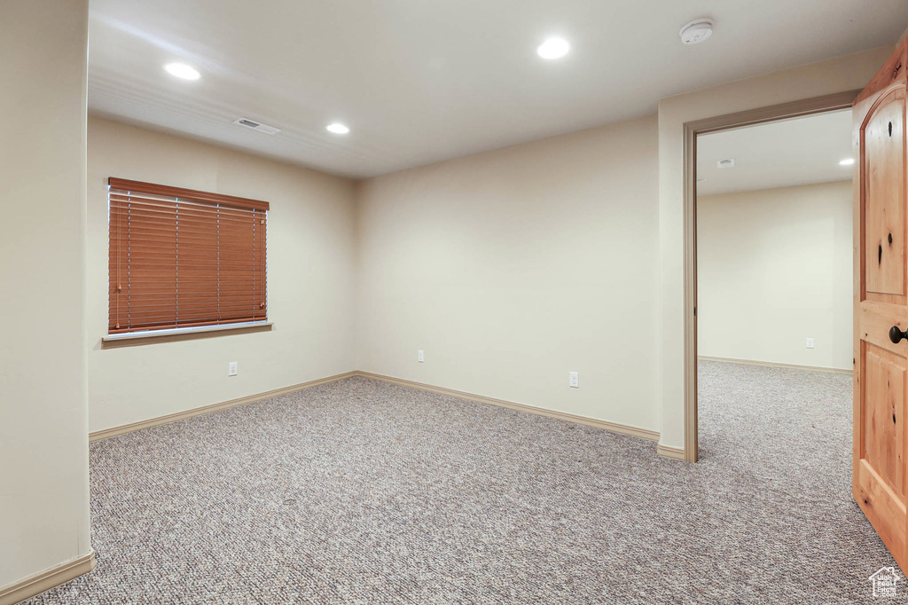 Carpeted spare room featuring recessed lighting and a smoke detector