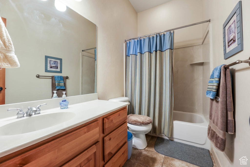 Bathroom with vanity, shower / bath combination with curtain, and tile patterned flooring