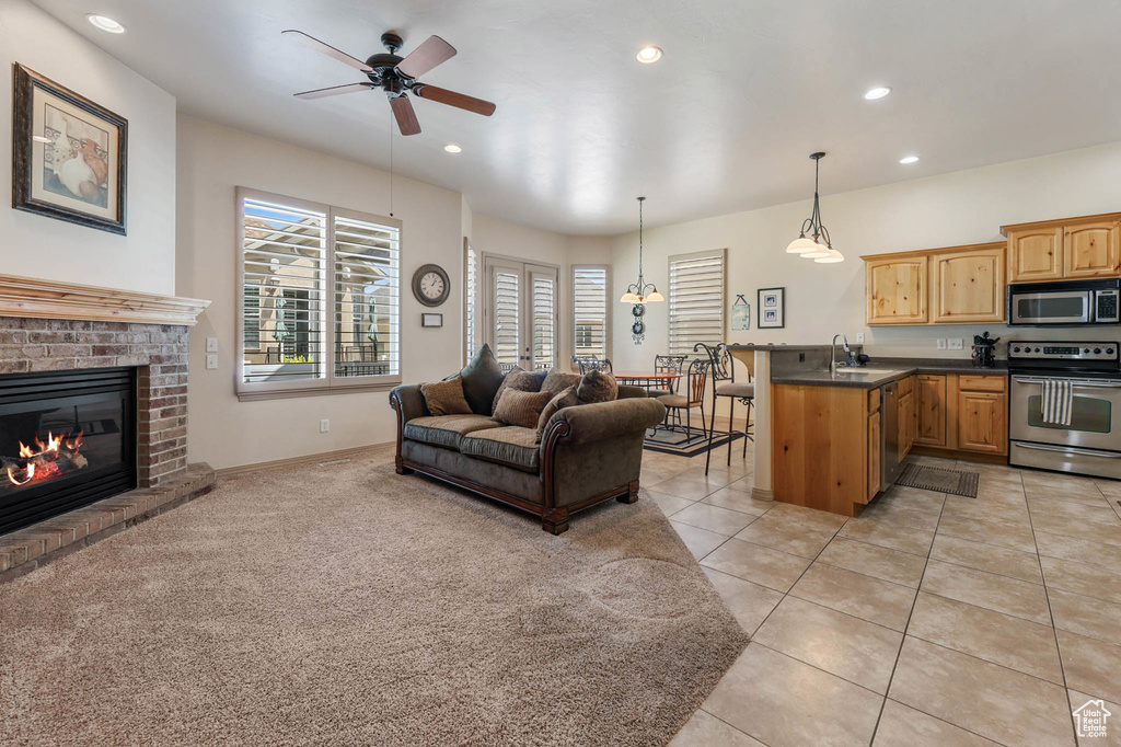 Living room featuring ceiling fan, recessed lighting, a fireplace, and light tile patterned floors