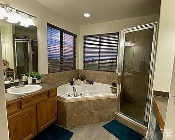 Full bathroom with vanity, a garden tub, and a shower stall