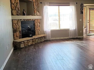 Unfurnished living room with wood-type flooring and a fireplace