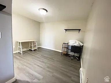 Home office featuring wood finished floors and a baseboard heating unit