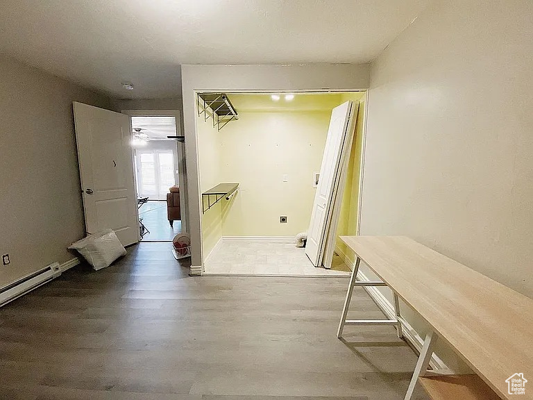 Corridor featuring wood finished floors and baseboard heating