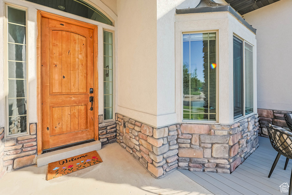 Doorway to property featuring stone siding and stucco siding