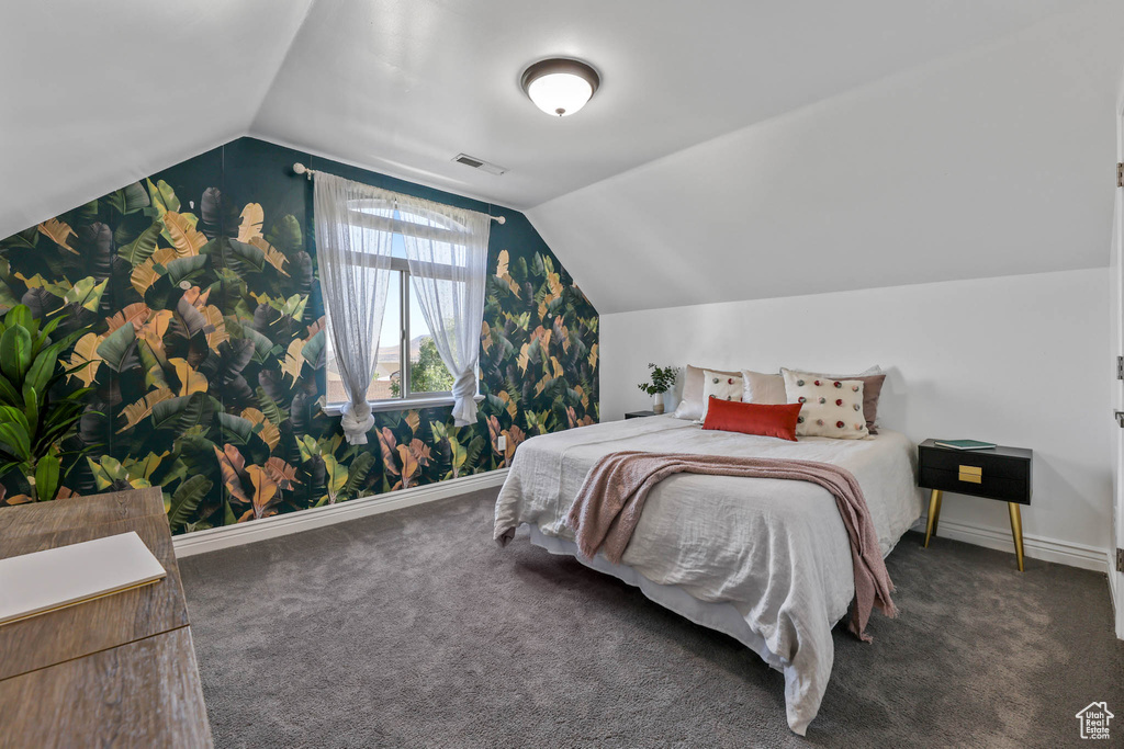 Carpeted bedroom featuring lofted ceiling and wallpapered walls