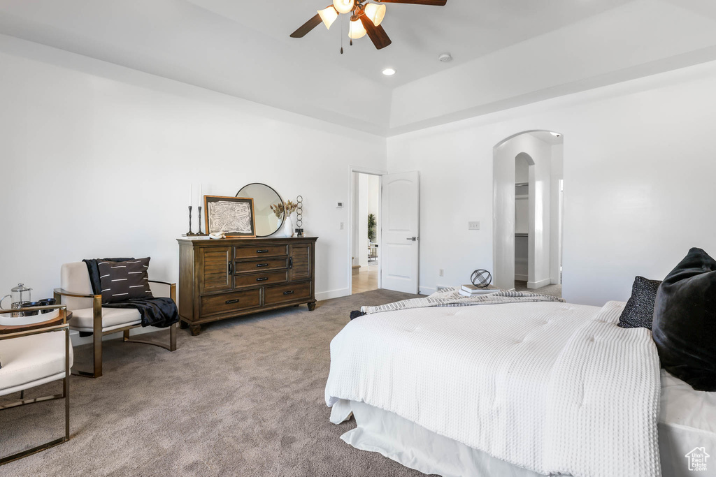 Carpeted bedroom featuring arched walkways and a ceiling fan