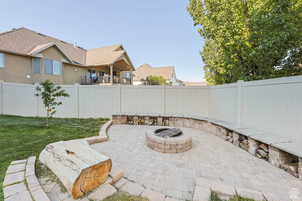 Fenced backyard featuring an outdoor fire pit and a patio