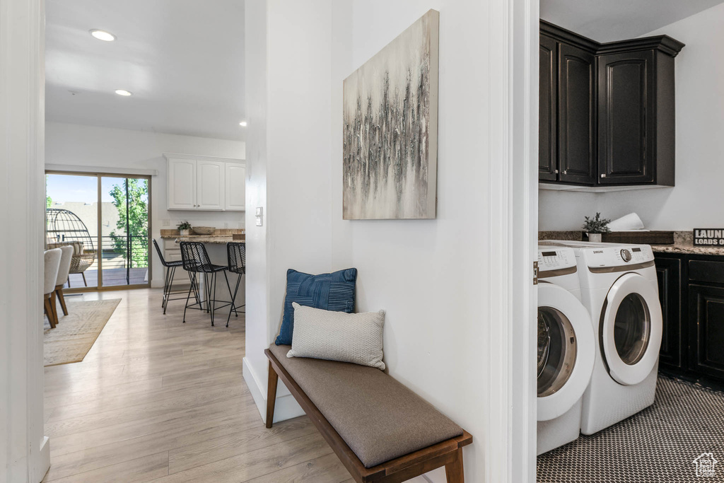 Laundry room featuring separate washer and dryer, cabinet space, light wood-style floors, and recessed lighting