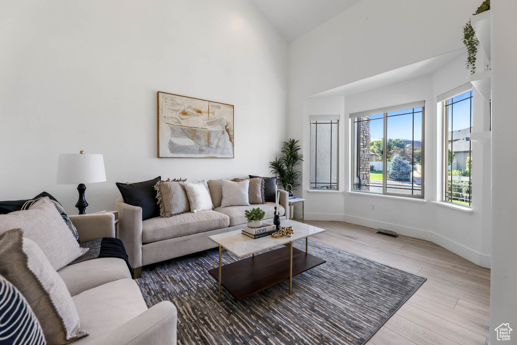 Living area featuring wood finished floors and a towering ceiling