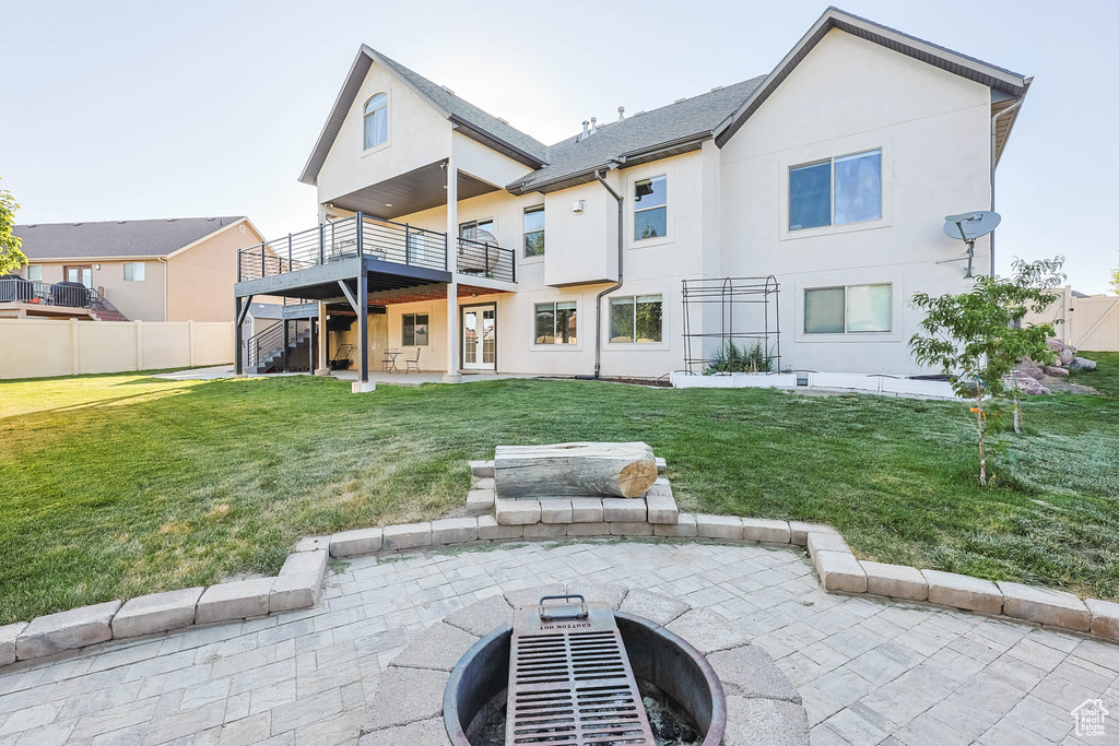 Back of house with a patio area, stucco siding, a fire pit, and a deck