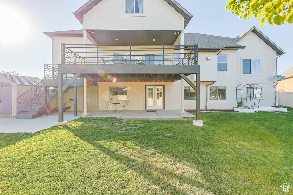 Rear view of house featuring french doors, a patio, stucco siding, a yard, and a deck