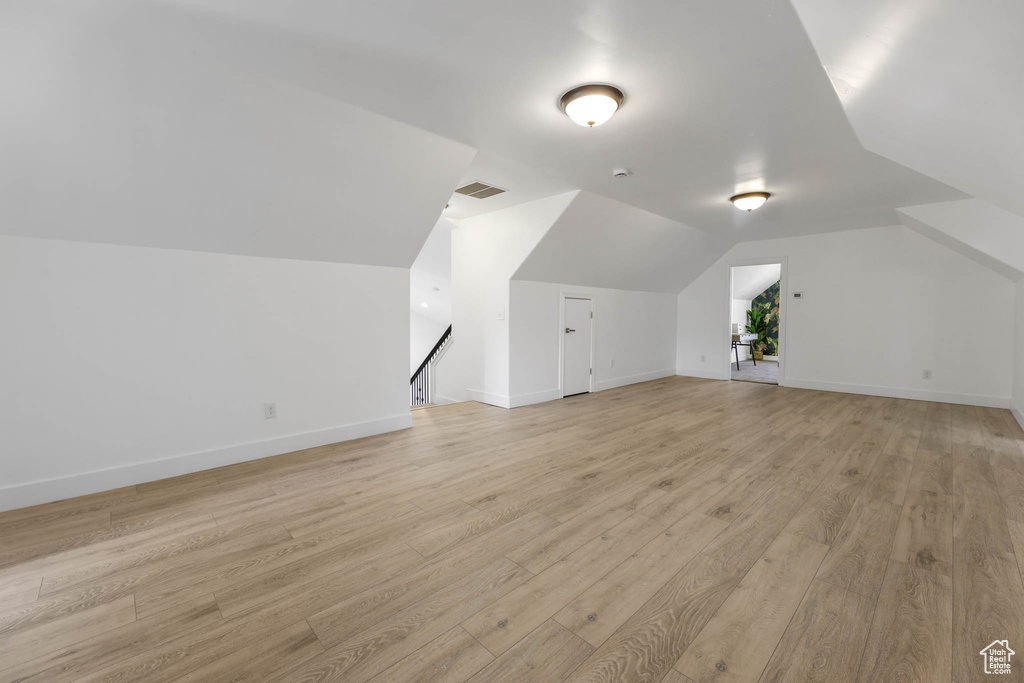 Additional living space with light wood finished floors and lofted ceiling