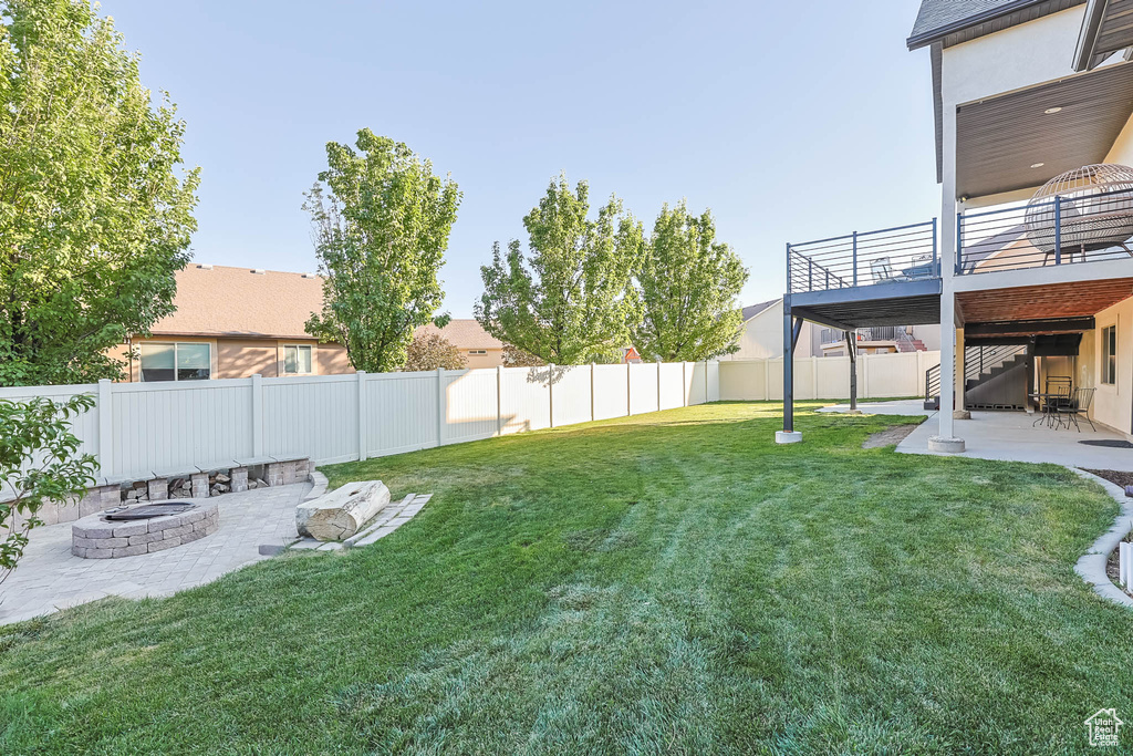 Fenced backyard with an outdoor fire pit, a patio, stairs, and a deck