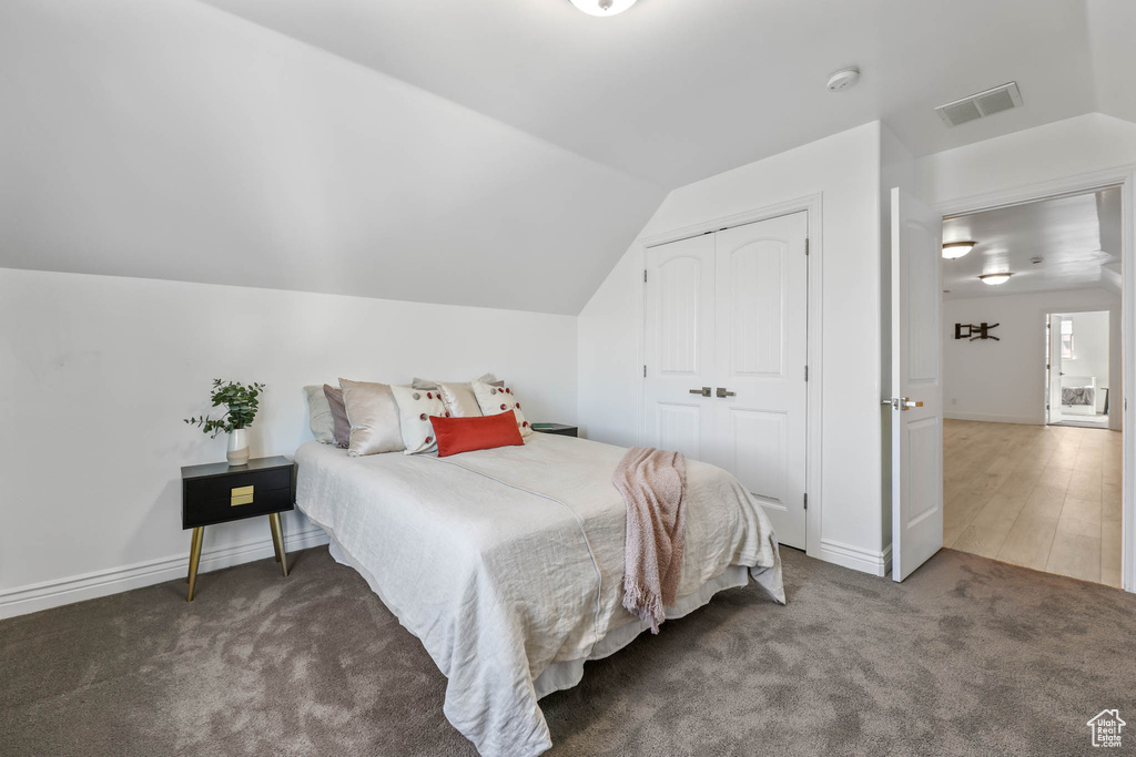 Bedroom with vaulted ceiling, carpet floors, and a closet