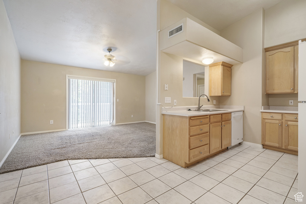Kitchen with light brown cabinetry, white dishwasher, light countertops, light carpet, and open floor plan