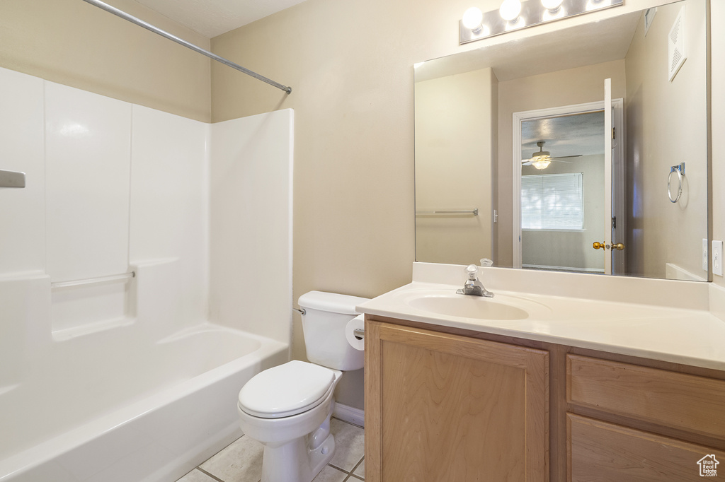Bathroom featuring vanity, tile patterned floors, washtub / shower combination, and a ceiling fan