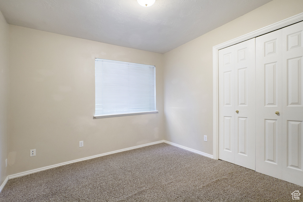 Unfurnished bedroom with carpet flooring and a closet