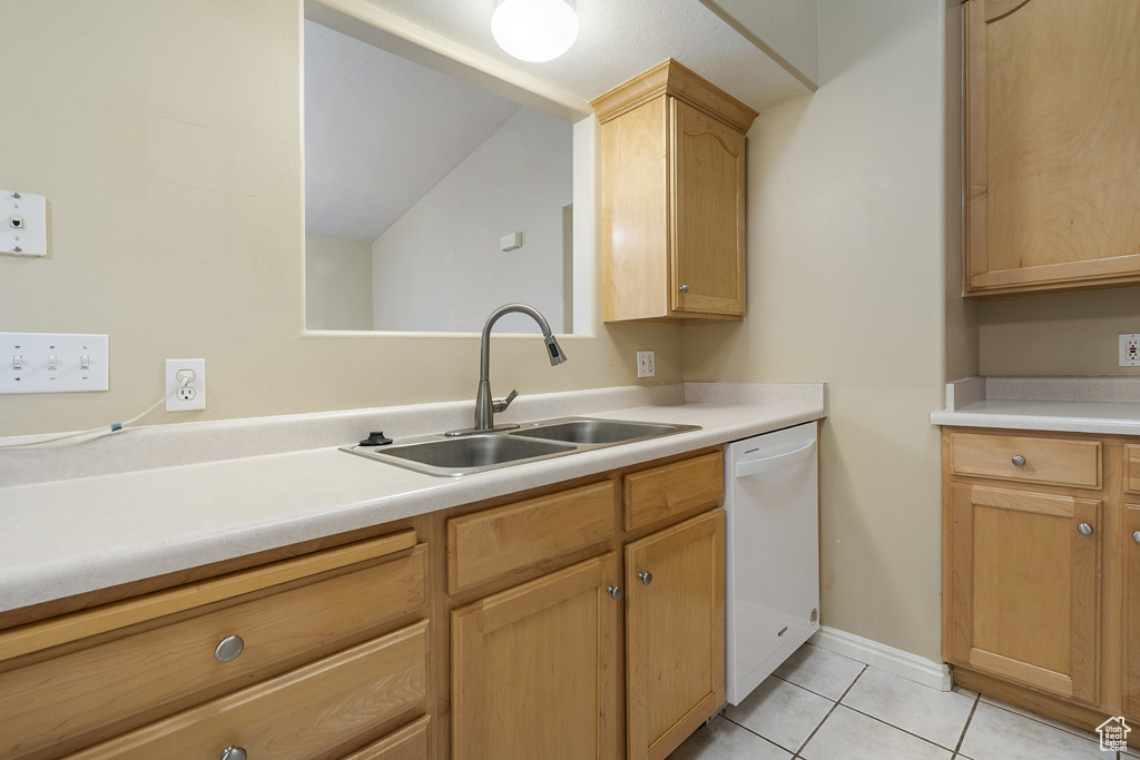 Kitchen with dishwasher, light tile patterned floors, light countertops, and light brown cabinets