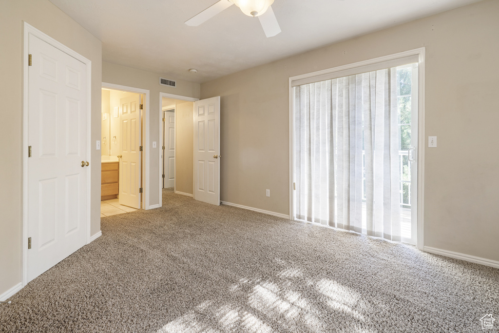 Unfurnished bedroom with carpet, connected bathroom, and ceiling fan