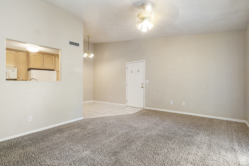 Spare room featuring light colored carpet and baseboards
