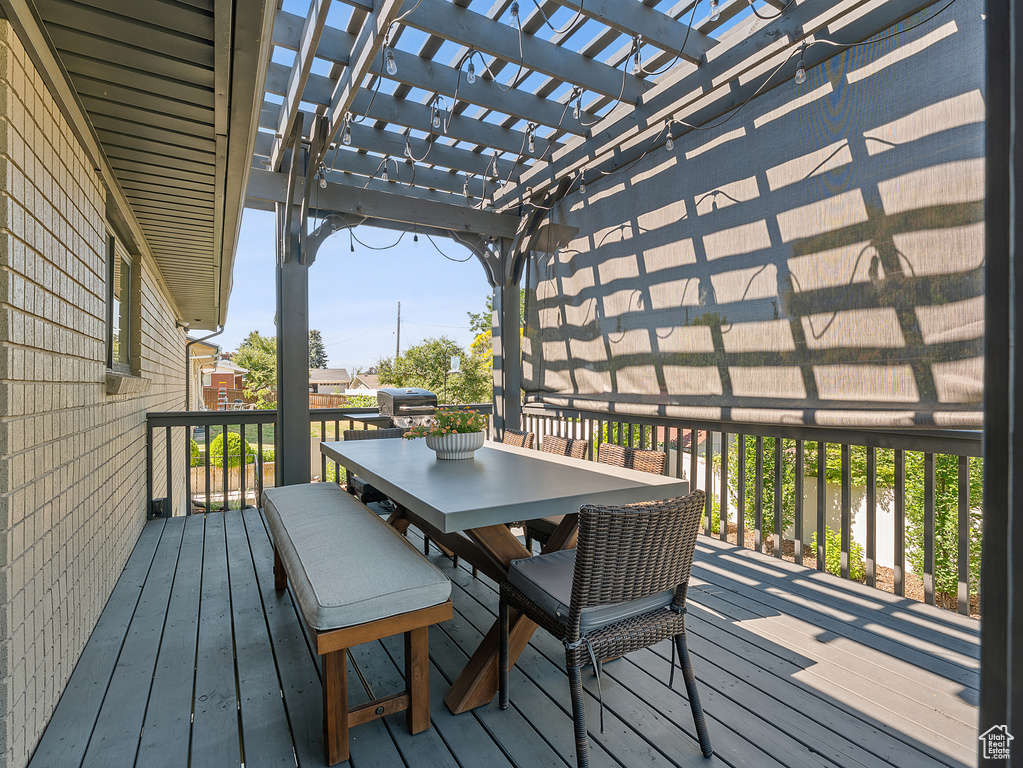Wooden terrace with outdoor dining area and a pergola