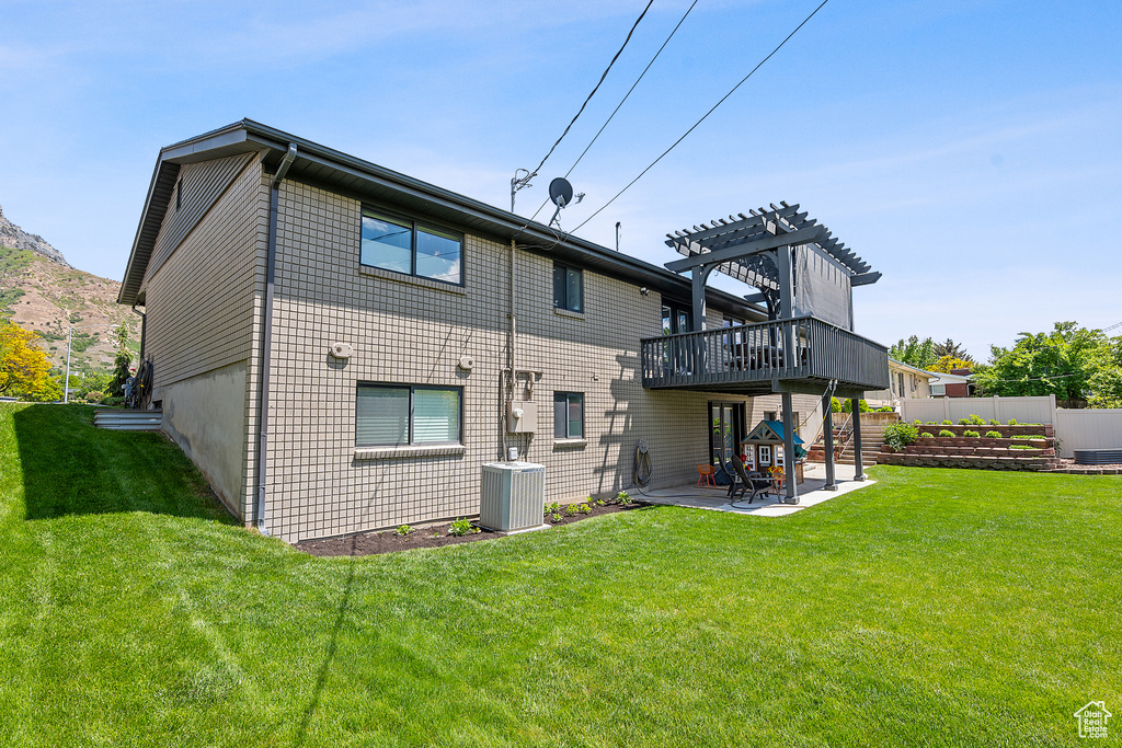 Rear view of house featuring a patio, a pergola, and a wooden deck