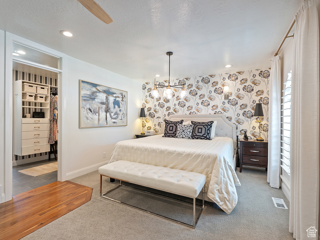 Bedroom with carpet, a spacious closet, and recessed lighting