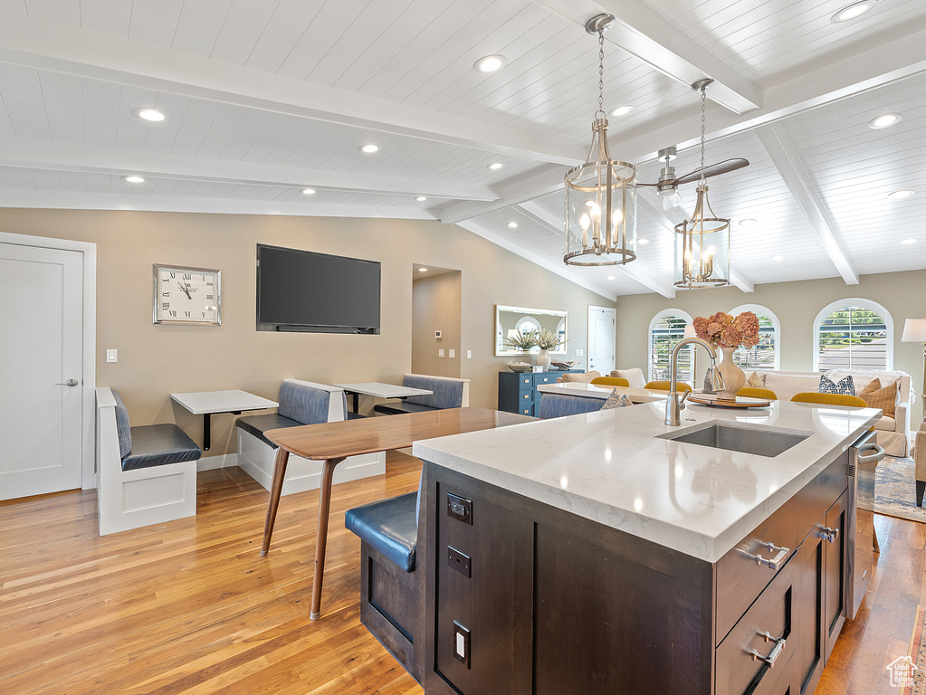 Kitchen with open floor plan, light wood finished floors, a kitchen island with sink, recessed lighting, and a chandelier