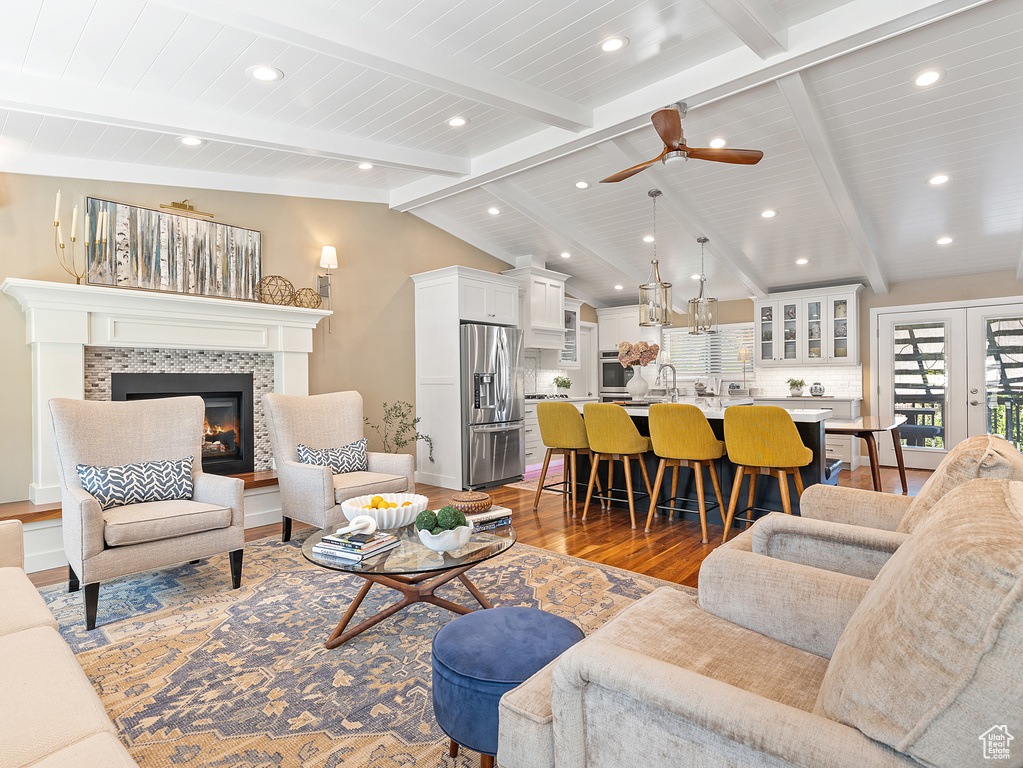 Living room with dark wood-style floors, a fireplace, ceiling fan, recessed lighting, and wooden ceiling