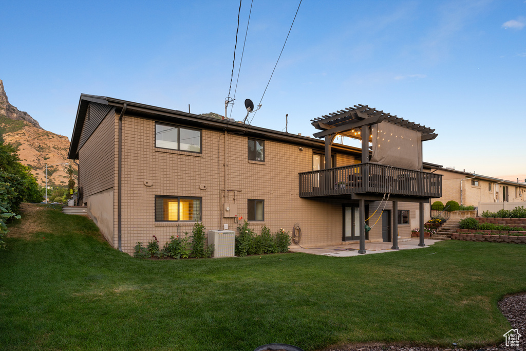 Back of house featuring a patio area, a pergola, a yard, and a deck with mountain view