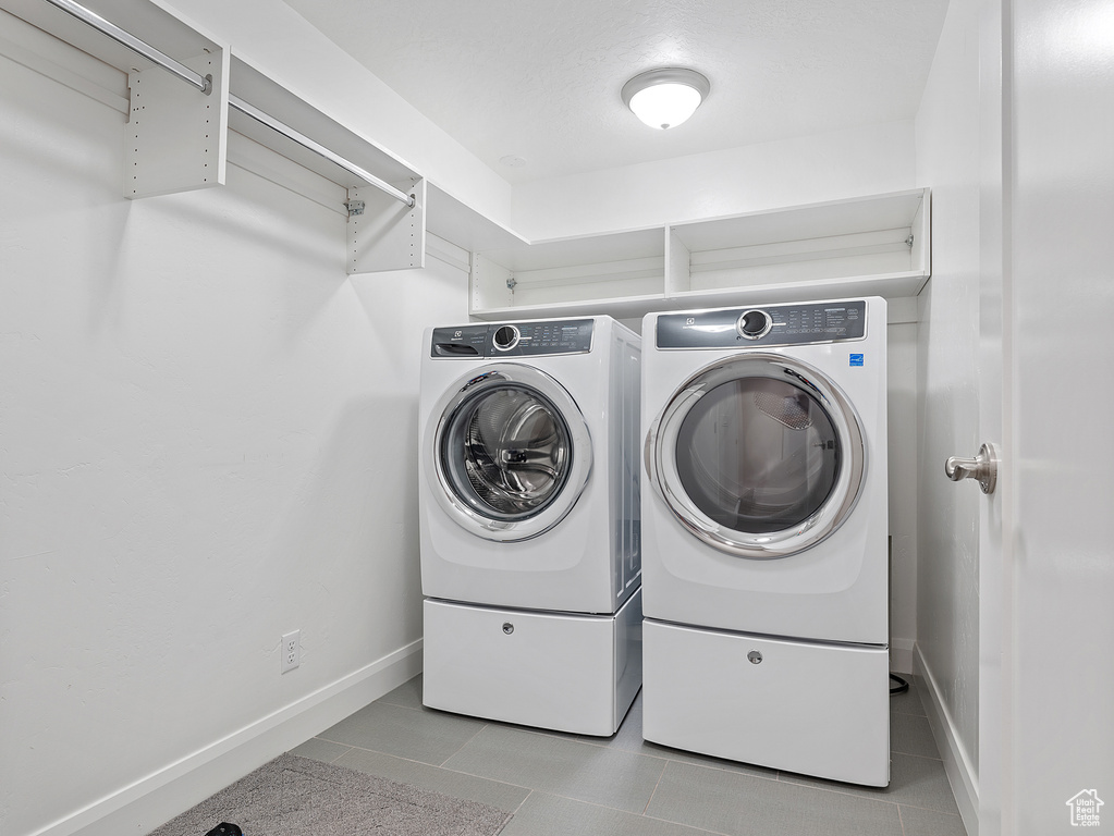 Laundry room featuring washing machine and clothes dryer and tile patterned flooring