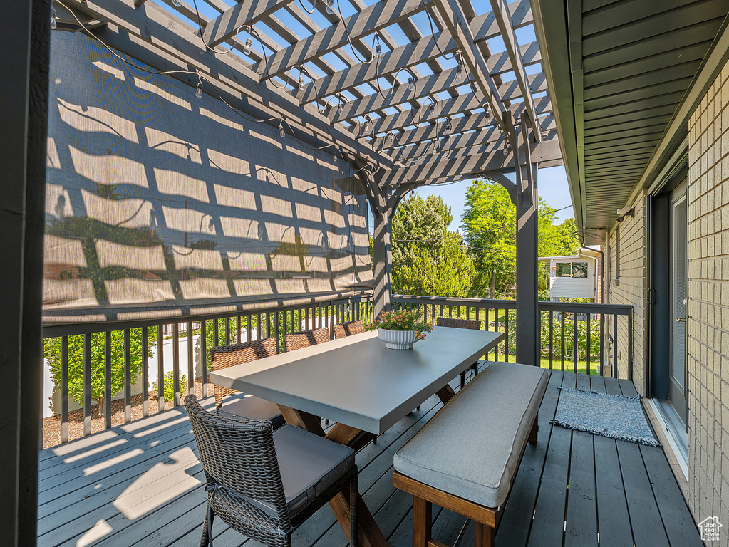 Wooden terrace featuring a pergola and outdoor dining area