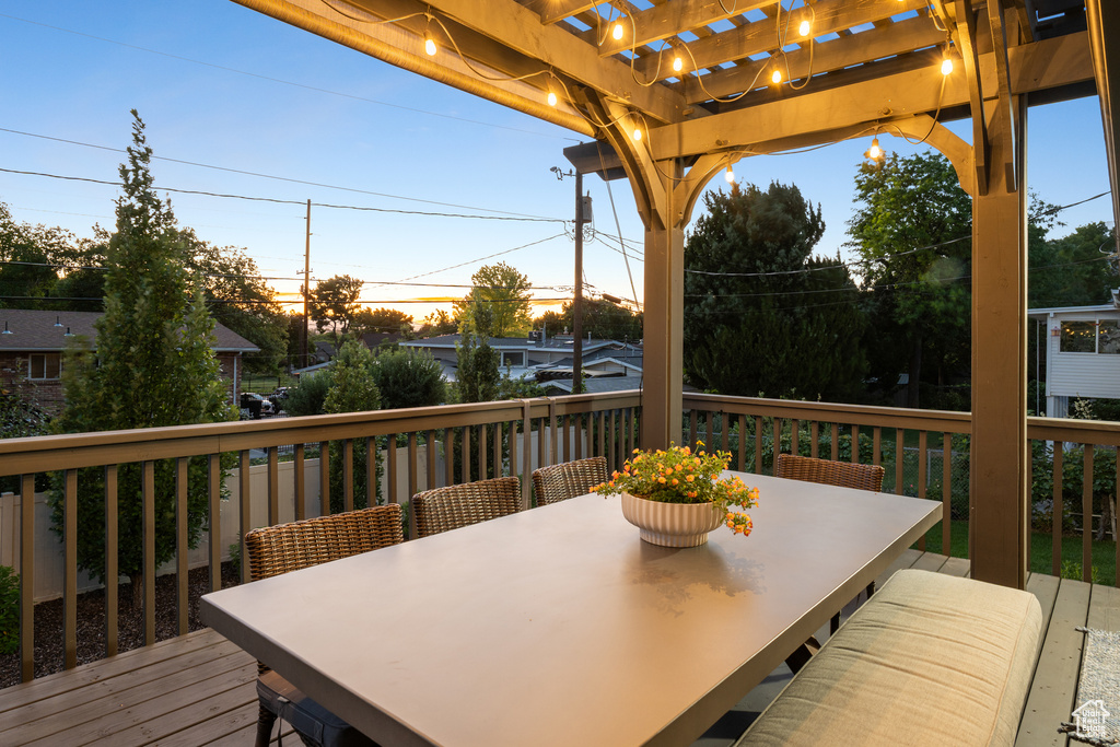 Wooden terrace featuring a pergola and outdoor dining space
