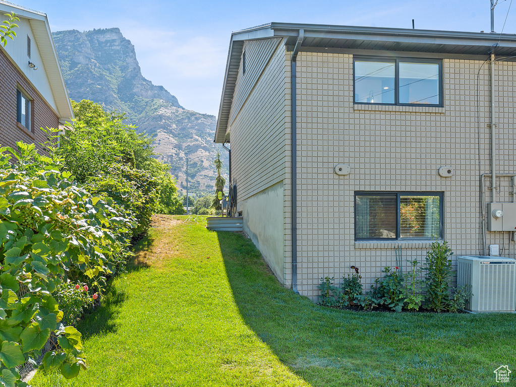 View of side of property featuring a mountain view and a yard