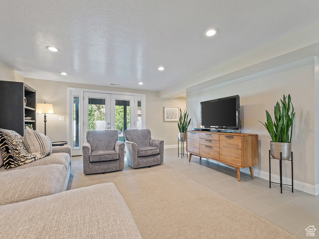 Tiled living room featuring recessed lighting, french doors, and a textured ceiling