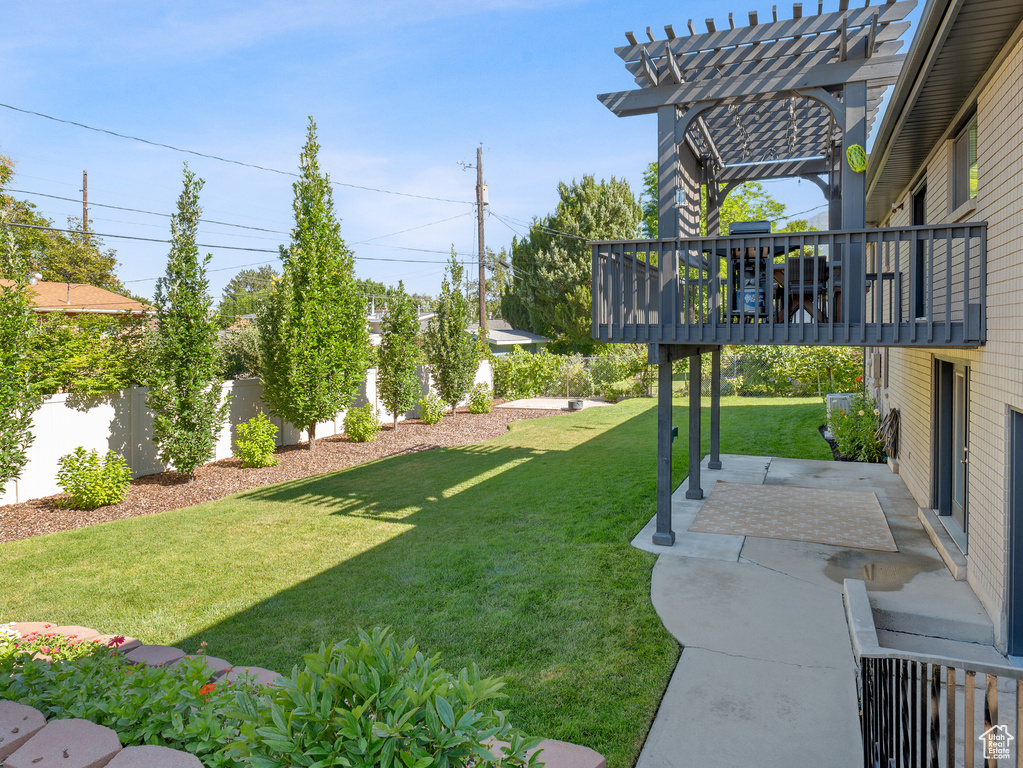 Fenced yard with a pergola, a patio, and a wooden deck