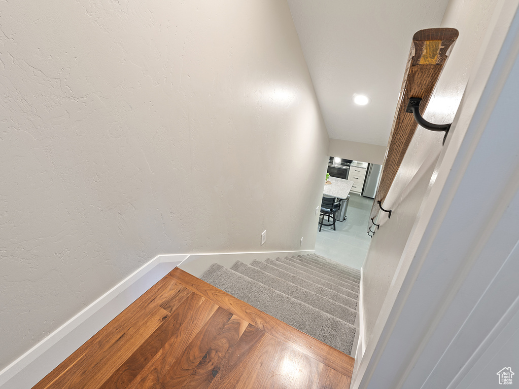 Staircase with baseboards and wood finished floors