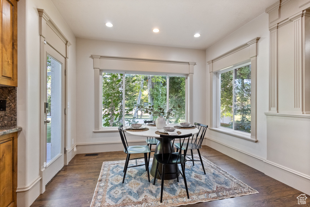 Dining room with dark wood-type flooring and recessed lighting