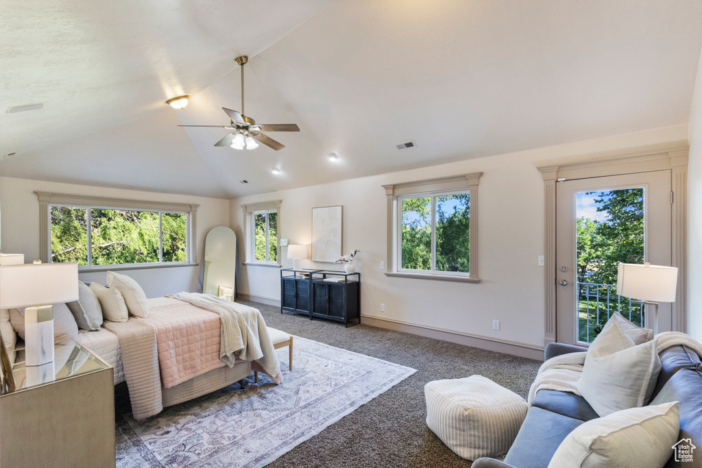Carpeted bedroom featuring vaulted ceiling, access to outside, multiple windows, and ceiling fan