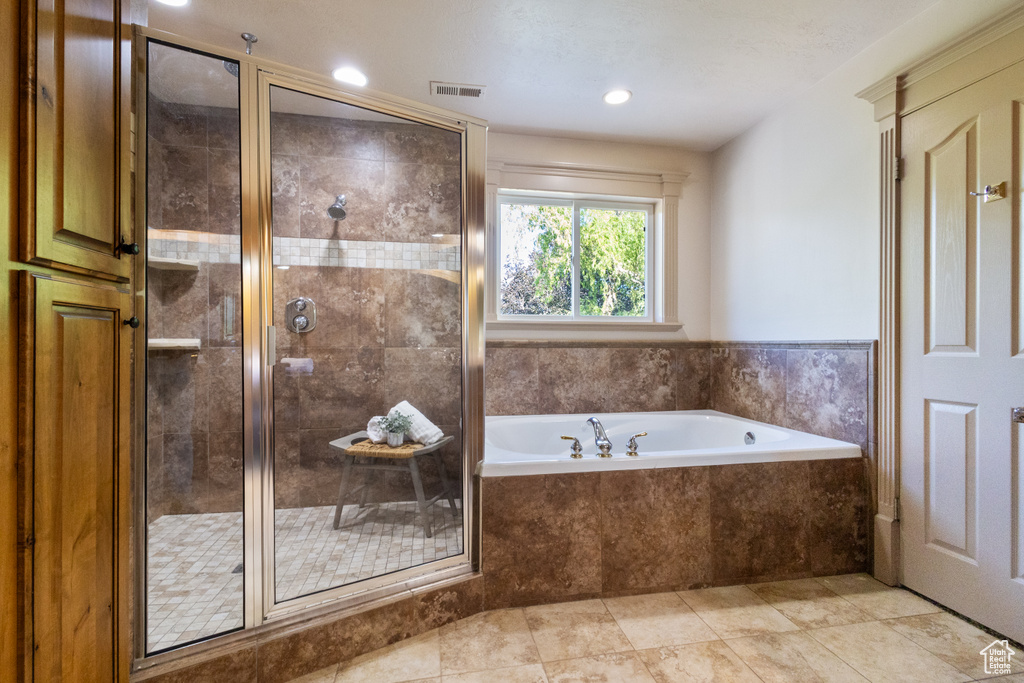Bathroom featuring a bath, a shower stall, recessed lighting, and tile patterned flooring