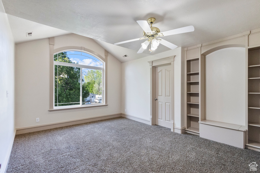 Unfurnished bedroom with carpet flooring, a ceiling fan, and lofted ceiling