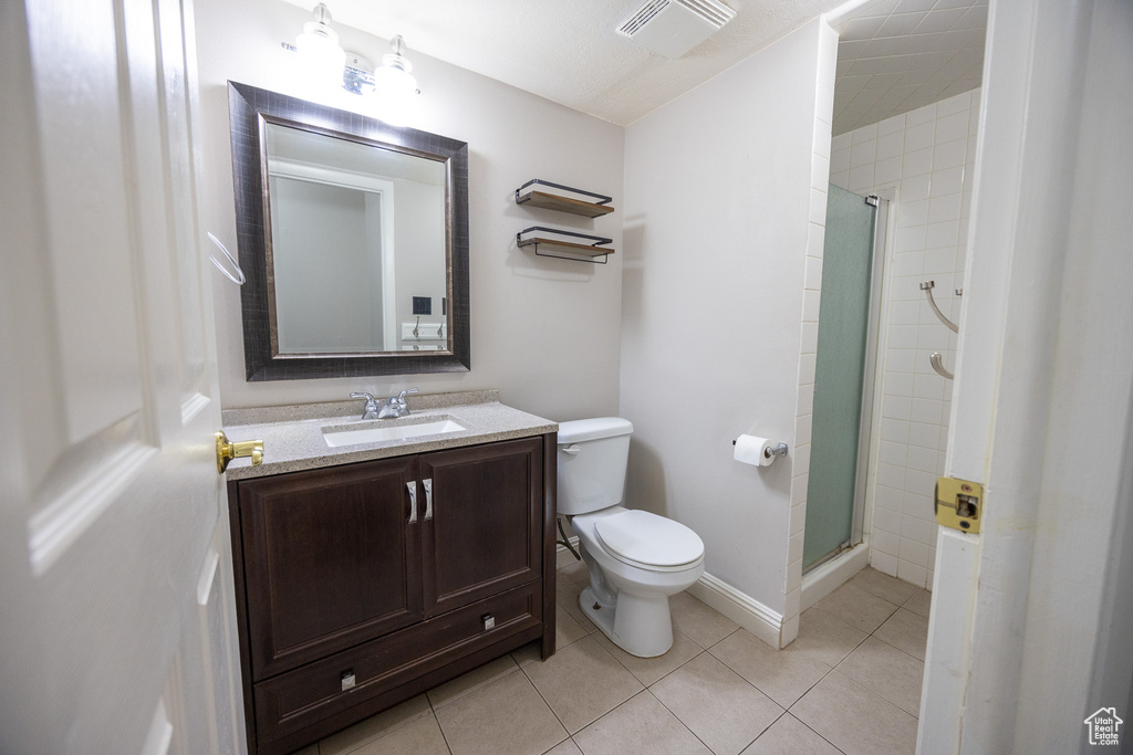 Bathroom with a shower stall, vanity, and tile patterned flooring