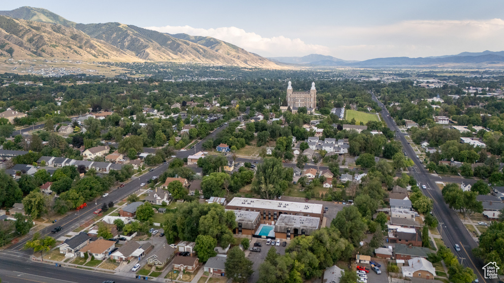 Aerial view of property and surrounding area featuring a mountain backdrop