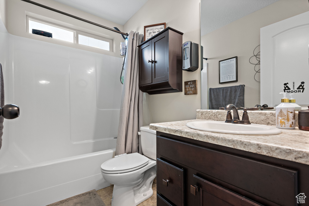 Bathroom featuring vanity, shower / bathtub combination with curtain, and tile patterned floors