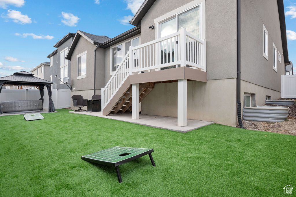 Back of property featuring a patio, a gazebo, stucco siding, a wooden deck, and stairway